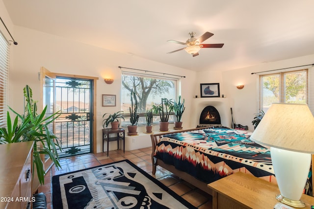 bedroom featuring access to exterior, light tile patterned floors, and ceiling fan