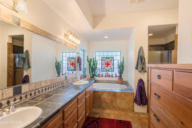 bathroom with vanity and shower with separate bathtub