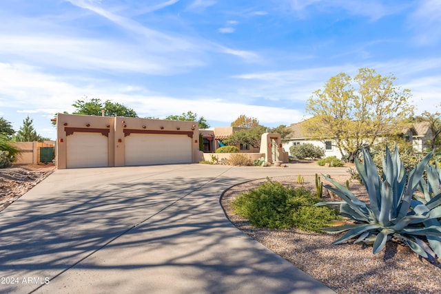 pueblo revival-style home with a garage