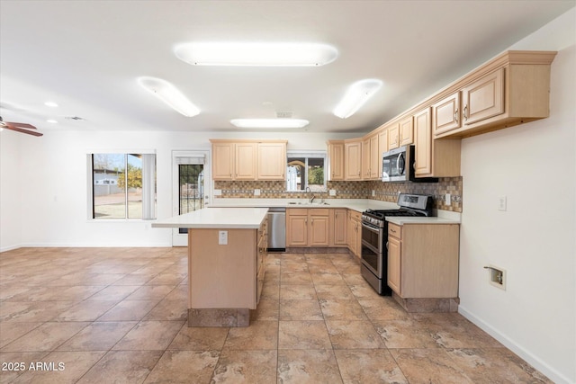 kitchen featuring light brown cabinets, sink, a healthy amount of sunlight, a center island, and stainless steel appliances