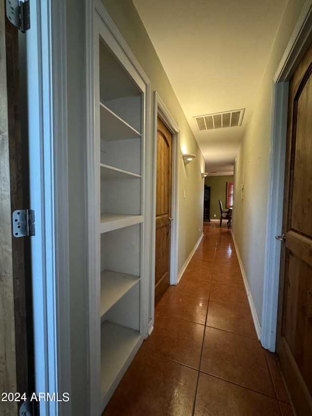 hall featuring dark tile patterned flooring