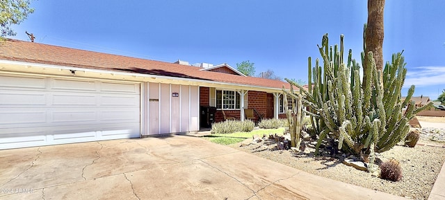ranch-style house with driveway, covered porch, an attached garage, and board and batten siding