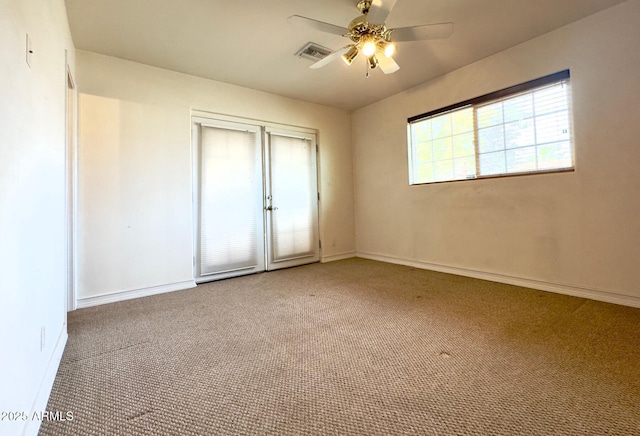 unfurnished bedroom with visible vents, a ceiling fan, carpet flooring, and baseboards