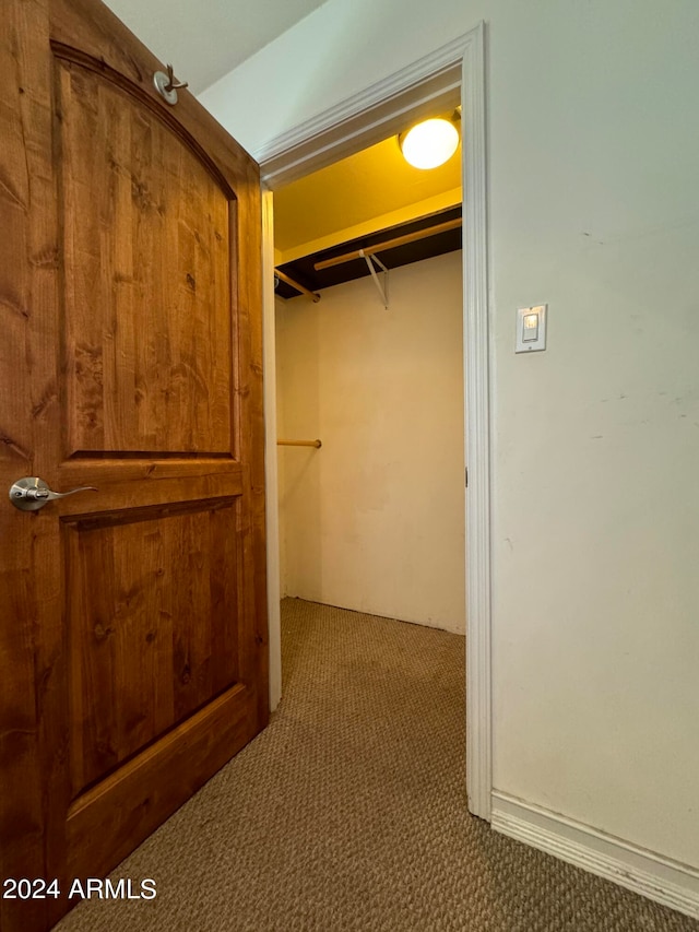 walk in closet featuring dark colored carpet