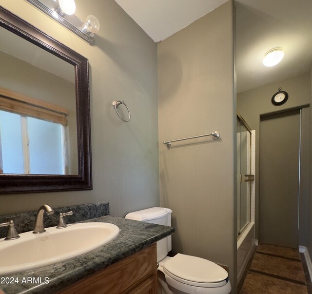 full bathroom with combined bath / shower with glass door, vanity, toilet, and tile patterned flooring