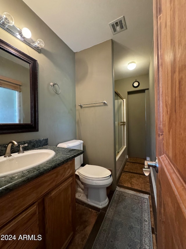 full bathroom with shower / bath combination with glass door, vanity, and toilet