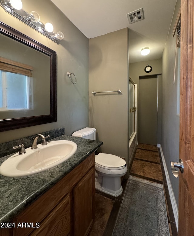full bathroom featuring tile patterned flooring, combined bath / shower with glass door, toilet, vanity, and visible vents