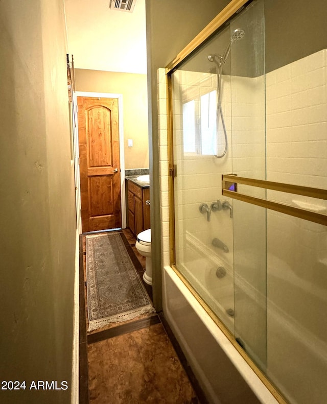 full bathroom with visible vents, bath / shower combo with glass door, toilet, and vanity