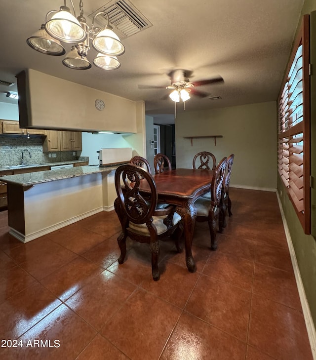 tiled dining space featuring ceiling fan, sink, and a textured ceiling