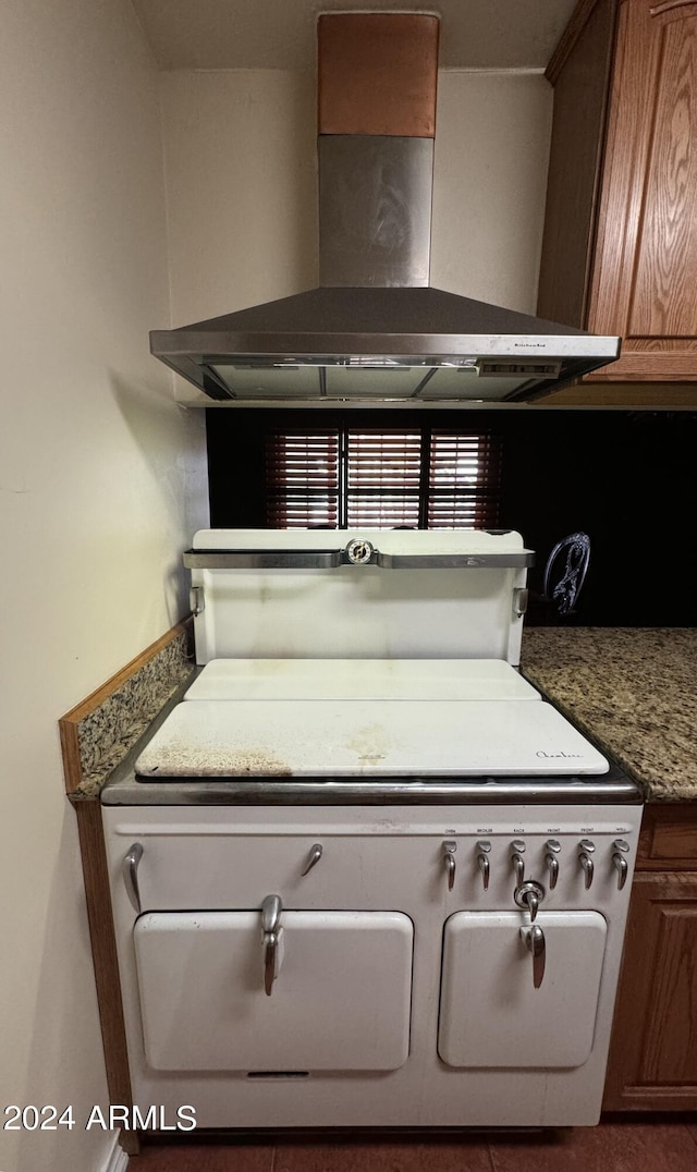 room details featuring brown cabinets and wall chimney range hood