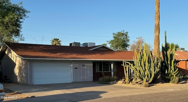 single story home featuring roof with shingles, concrete driveway, board and batten siding, and a garage