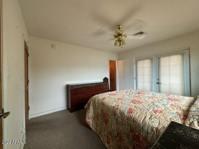 carpeted bedroom featuring visible vents, ceiling fan, and baseboards