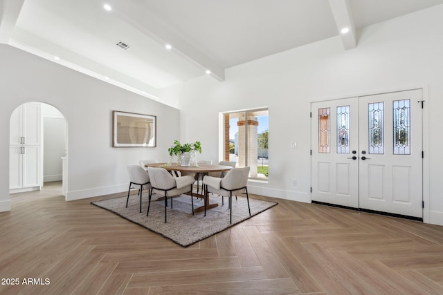 dining area featuring beam ceiling and light parquet floors