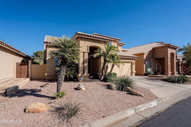 1227 E Sheena Dr, Phoenix, AZ 85022 - mediterranean / spanish-style house featuring stucco siding, driveway, a tiled roof, a garage, and a gate