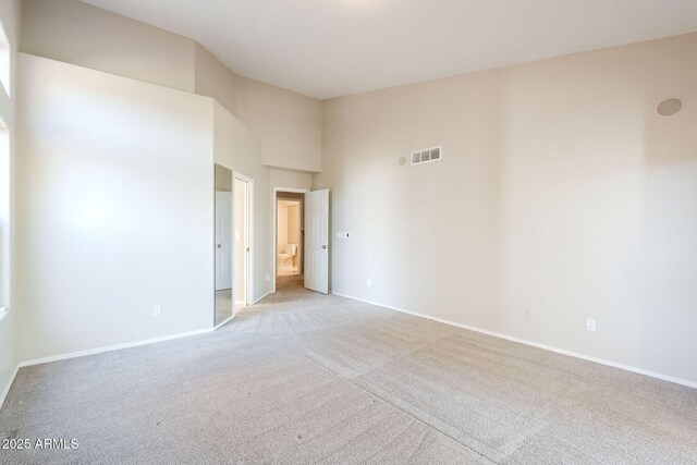 1227 E Sheena Dr, Phoenix, AZ 85022 - empty room featuring light carpet, baseboards, and a towering ceiling