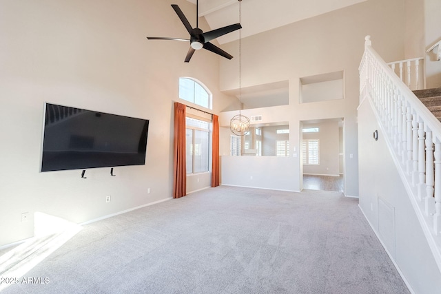 1227 E Sheena Dr, Phoenix, AZ 85022 - unfurnished living room with stairs, plenty of natural light, carpet flooring, a ceiling fan, and a high ceiling