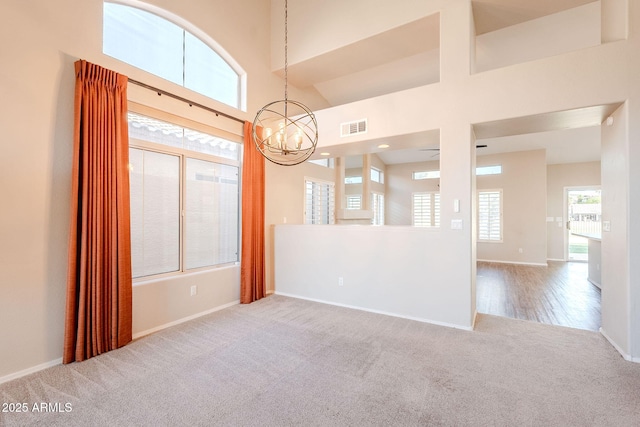 1227 E Sheena Dr, Phoenix, AZ 85022 - carpeted empty room featuring a chandelier, baseboards, and a towering ceiling