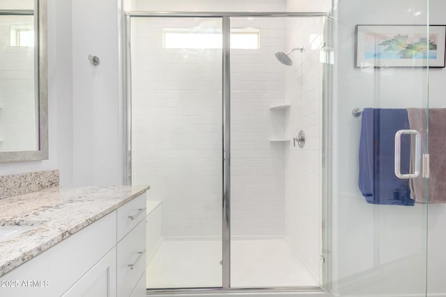 bathroom with vanity and a shower with shower door