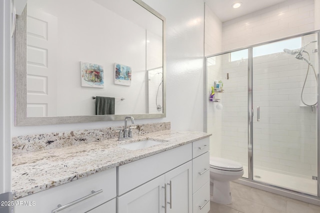 bathroom featuring vanity, toilet, and a shower with door