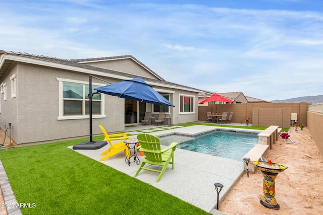 view of pool with a patio area and a lawn