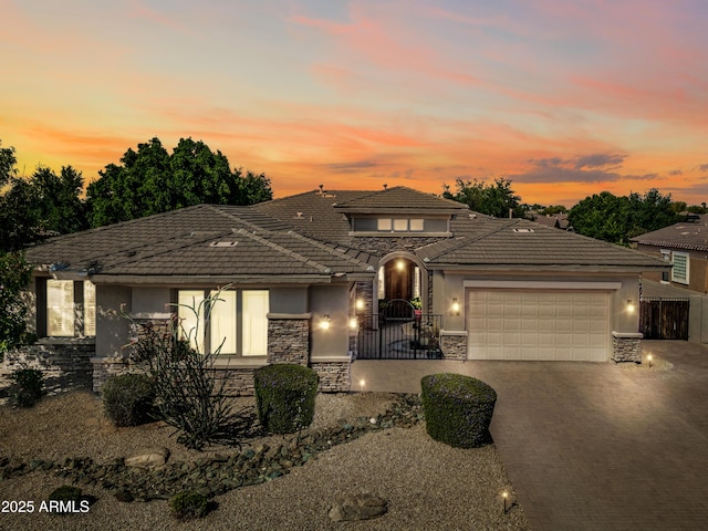 2565 N 141st Ln, Goodyear, AZ 85395 - view of front of home with stone siding, stucco siding, an attached garage, and a tile roof