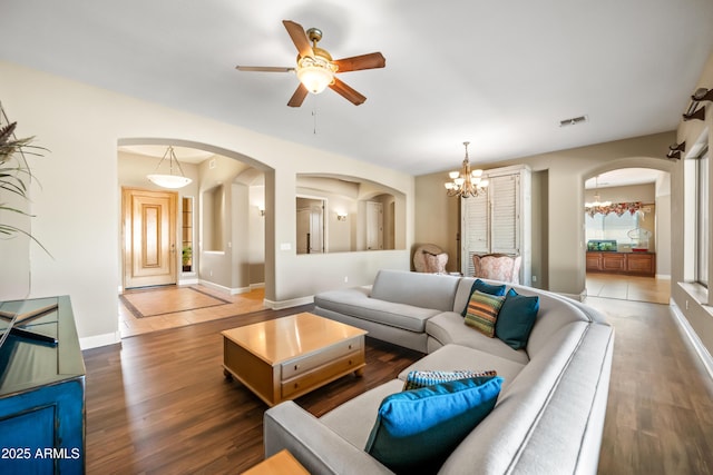 2565 N 141st Ln, Goodyear, AZ 85395 - living room with arched walkways, a ceiling fan, a chandelier, and wood finished floors