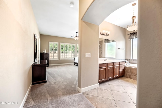 2565 N 141st Ln, Goodyear, AZ 85395 - ensuite bathroom with vanity, tiled tub, ceiling fan, and baseboards