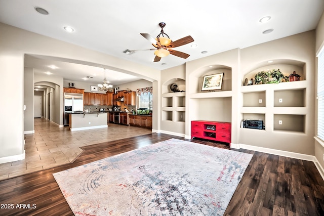 2565 N 141st Ln, Goodyear, AZ 85395 - living area with a chandelier, built in shelves, arched walkways, ceiling fan, and baseboards
