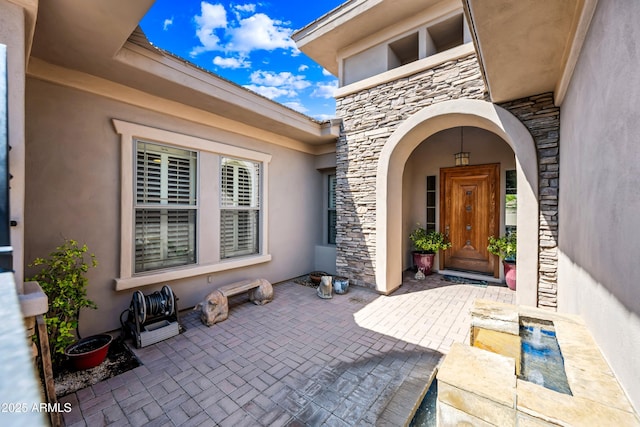 2565 N 141st Ln, Goodyear, AZ 85395 - entrance to property featuring stone siding, stucco siding, and a patio