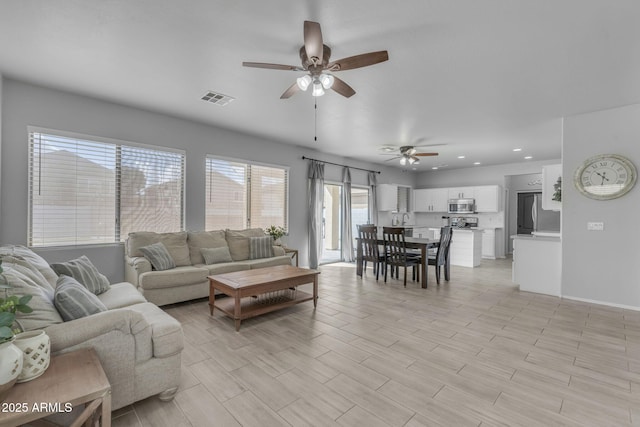 living area with visible vents, recessed lighting, ceiling fan, and wood tiled floor