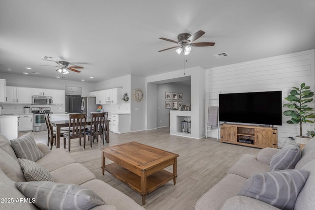 living area with visible vents, recessed lighting, light wood-style floors, and a ceiling fan