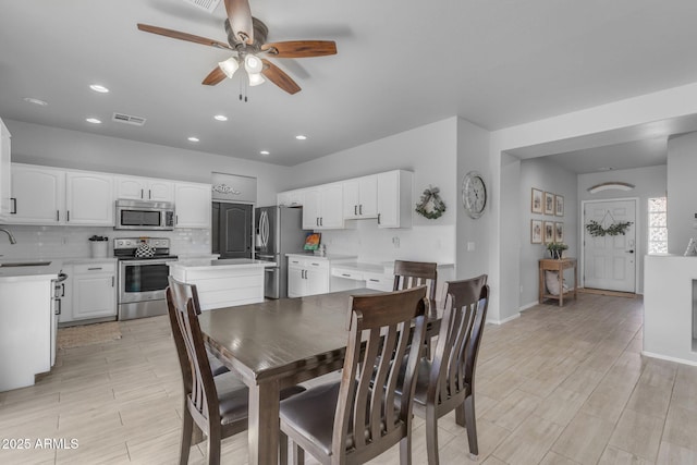 dining space featuring baseboards, visible vents, wood finish floors, recessed lighting, and ceiling fan