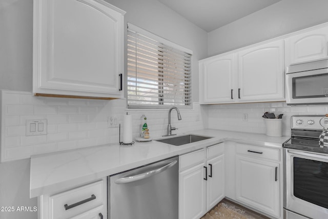 kitchen with a sink, backsplash, appliances with stainless steel finishes, and white cabinets