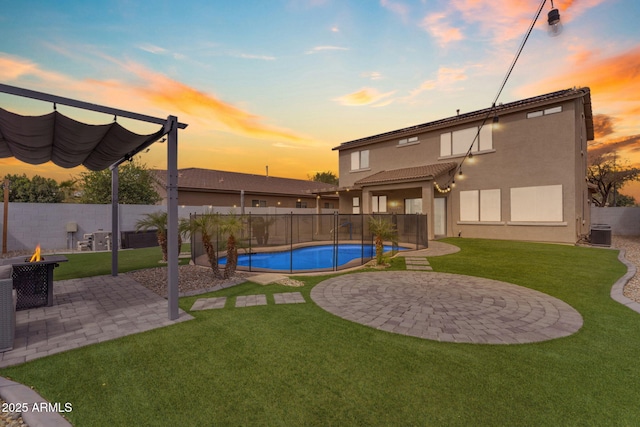 exterior space with stucco siding, a patio, cooling unit, a yard, and a fire pit