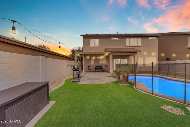 back of house with a fenced in pool, stucco siding, a yard, a fenced backyard, and a patio