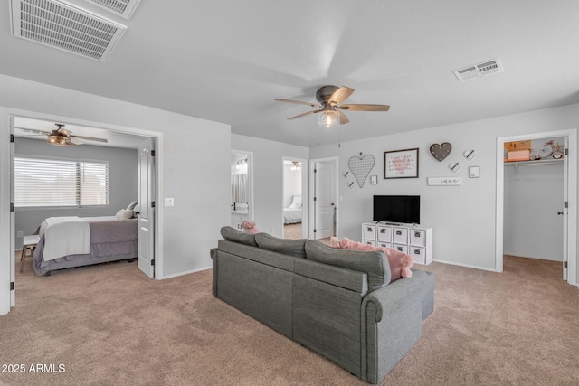 living area with light carpet, visible vents, and ceiling fan