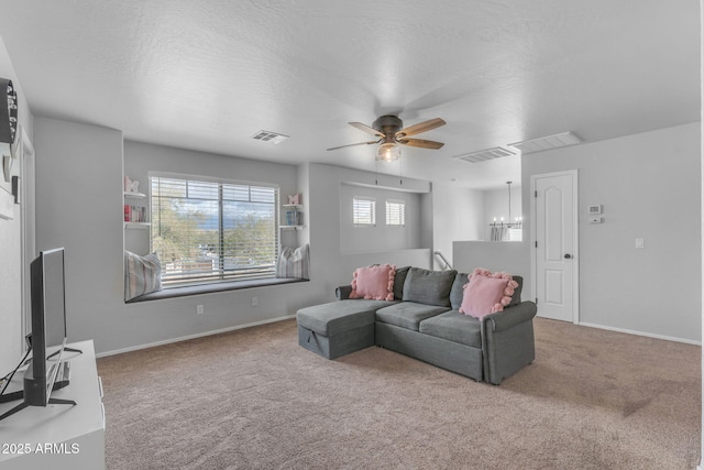 living room with carpet flooring, ceiling fan with notable chandelier, and visible vents