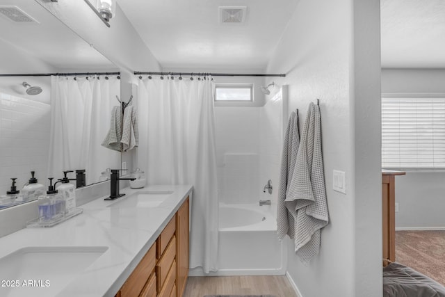 bathroom featuring shower / bathtub combination with curtain, visible vents, and a sink