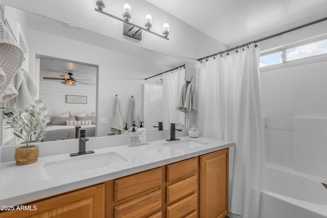 bathroom featuring double vanity, ensuite bath, ceiling fan, and a sink