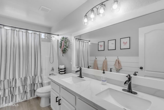 full bathroom featuring a sink, visible vents, toilet, and double vanity