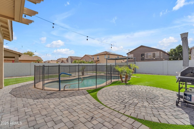 view of swimming pool with a fenced backyard, a lawn, and a patio