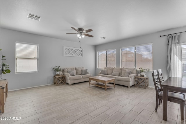 living area with visible vents, light wood-style flooring, and a ceiling fan