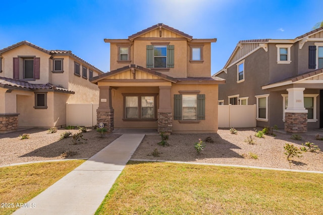 view of front of home with stone siding, stucco siding, and fence