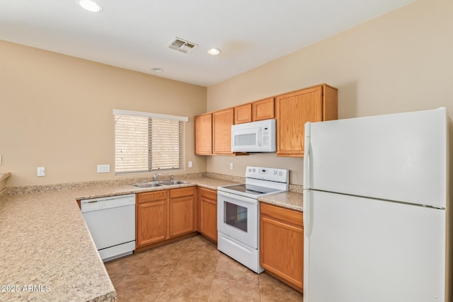 kitchen with visible vents, light countertops, light tile patterned flooring, white appliances, and a sink