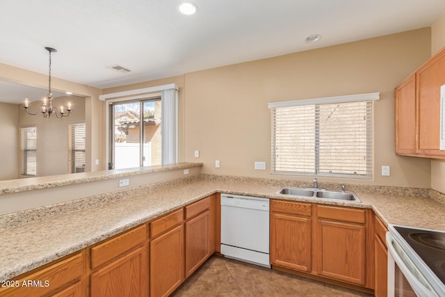 kitchen featuring visible vents, white appliances, light countertops, and a sink