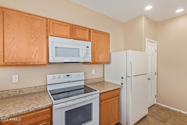 kitchen featuring recessed lighting, white appliances, light tile patterned floors, and light countertops