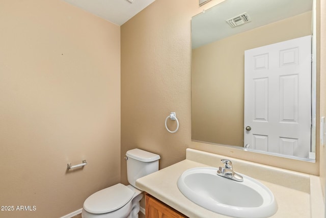 bathroom featuring visible vents, toilet, and vanity