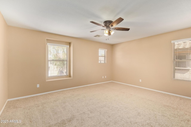 carpeted empty room featuring visible vents, ceiling fan, and baseboards