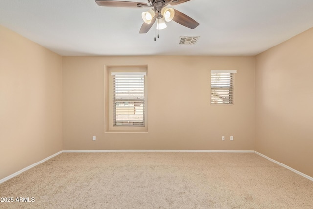 spare room with baseboards, visible vents, carpet floors, and ceiling fan