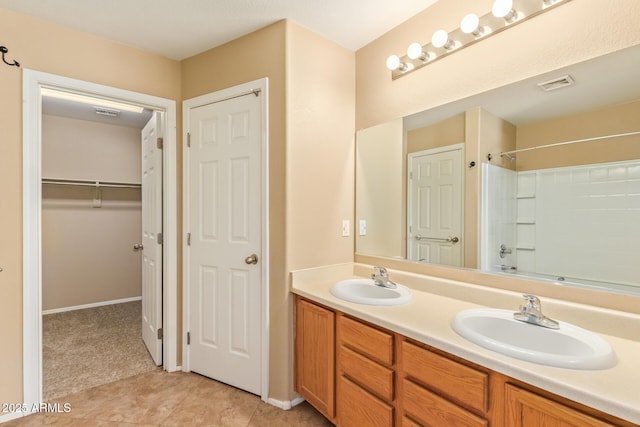 bathroom with double vanity, visible vents, tile patterned flooring, and a sink